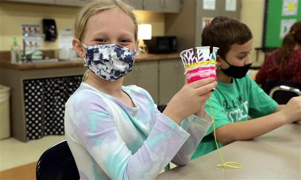 student creates woven craft